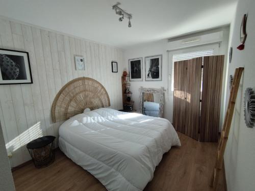 - une chambre avec un grand lit blanc dans l'établissement Chez Damien, à Pontarlier