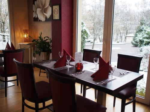 a dining room with a table with wine glasses at The Originals City, Hôtel et Restaurant Aster, Saint-Avold Nord in Creutzwald-la-Croix