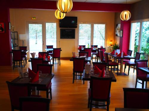 a dining room with tables and chairs and windows at The Originals City, Hôtel et Restaurant Aster, Saint-Avold Nord in Creutzwald-la-Croix