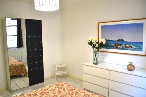 ein Schlafzimmer mit einer Kommode und einer Blumenvase in der Unterkunft Charmante maison centre historique d'Arles in Arles