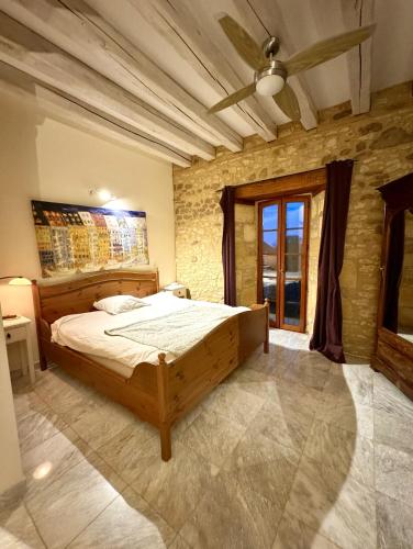 une chambre avec un lit et un ventilateur de plafond dans l'établissement Les Constancies luxury Villa 24-34 pers, à Valades