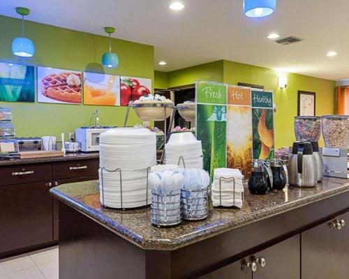a kitchen with a counter with plates and utensils at Quality Suites in Sulphur