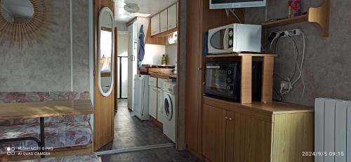 La cuisine est équipée d'un four micro-ondes et d'un four traditionnel. dans l'établissement Mobil home dans camping calme proche plage, à Meschers-sur-Gironde
