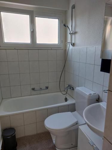 a bathroom with a toilet and a tub and a sink at El Destino Apartments in Zürich