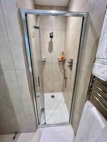 a shower with a glass door in a bathroom at Hotel at Home in Shoreham by Sea in Shoreham-by-Sea