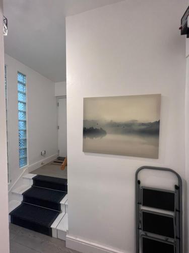a hallway with stairs and a painting on the wall at 2 Bed Apartment in Central London on 3rd floor - Newly refurbished - No lift in London