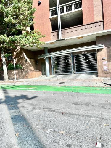 an empty street in front of a building with garage doors at Beautiful Uptown Adventure Apartment in Charlotte