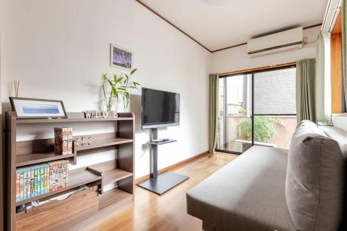 a living room with a couch and a television at kensui house in Tokyo