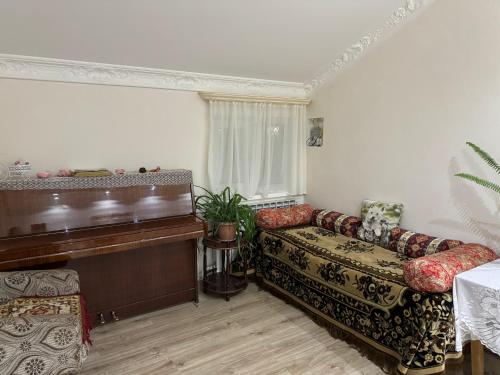 a living room with a couch and a piano at Green House in Dilijan