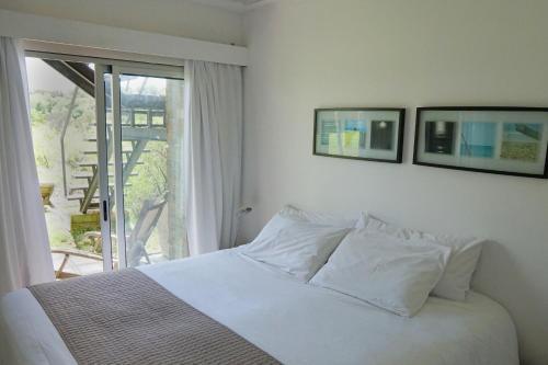 a white bed in a bedroom with a window at Dalarna Små Hotell in Punta del Este