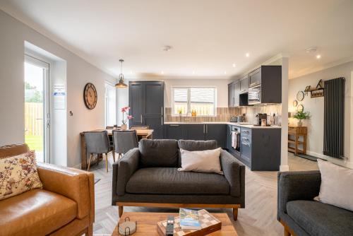 a living room with a couch and a kitchen at Cottage with Hot Tub near Knockhill in Saline