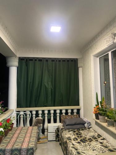 a green curtain in a room with two beds at Green House in Dilijan