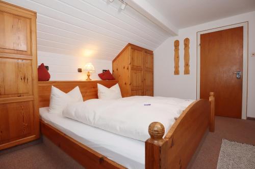 a bedroom with a large bed with white sheets at Landgasthaus Kurz Hotel & Restaurant am Feldberg - Schwarzwald in Todtnau