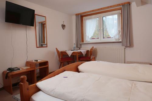 a room with a bed and a table and a window at Landgasthaus Kurz Hotel & Restaurant am Feldberg - Schwarzwald in Todtnau