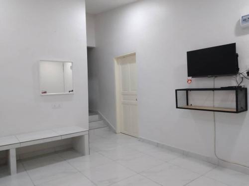 a white room with a tv on a wall at Cempaka Homestay Batu Pahat 21 in Batu Pahat
