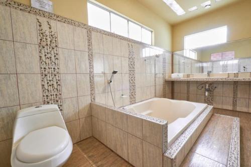 a bathroom with a toilet and a bath tub at La Casa de Algodon in Huacho