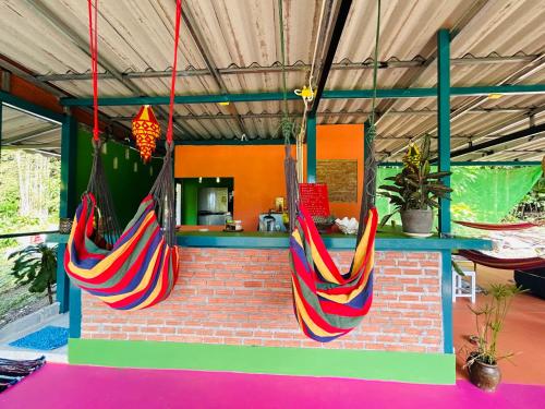 two colorful hammocks hanging from a brick wall at Hippy Hut Koh Chang in Ko Chang