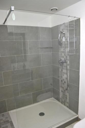 une salle de bain avec une douche avec une porte vitrée dans l'établissement Charmante maison centre historique d'Arles, à Arles