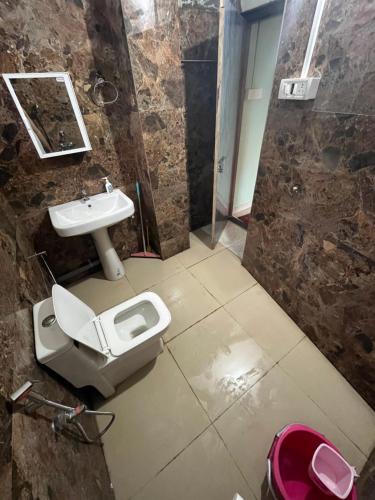 a bathroom with a toilet and a sink at Hemalata Hilltop Residency Kamakhya in Guwahati