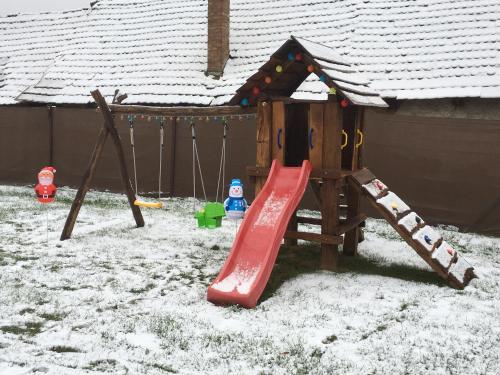 a playground in a yard covered in snow at Mátrai pincés udvar in Mátramindszent
