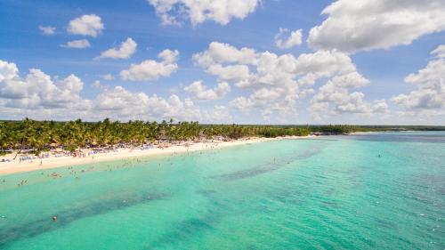 a view of a beach with people in the water at Catalonia Bayahibe - All Inclusive in Bayahibe
