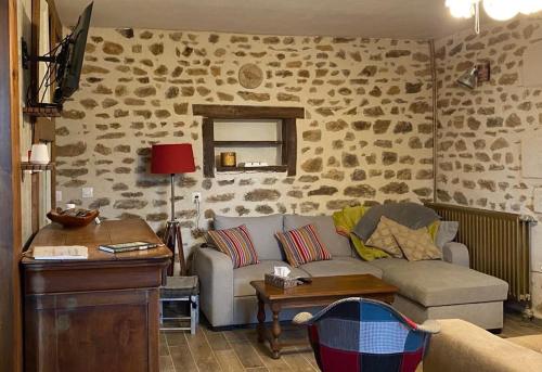 a living room with a couch and a table at Gîte La Cahute in Bourganeuf
