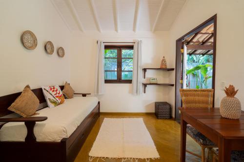 a room with a bed and a desk and a table at Pousada Samambaia in Trancoso