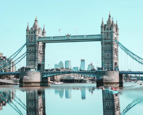 a bridge over a river with a city in the background at London Rooms King's Cross in London