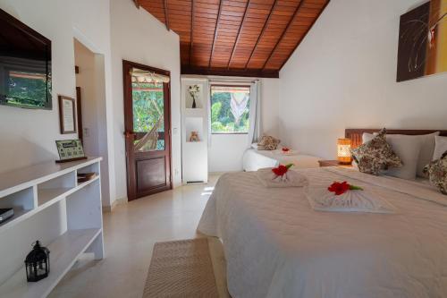 a bedroom with a large bed with red flowers on it at Pousada Samambaia in Trancoso