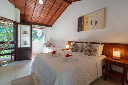 a bedroom with a large bed with red flowers on it at Pousada Samambaia in Trancoso