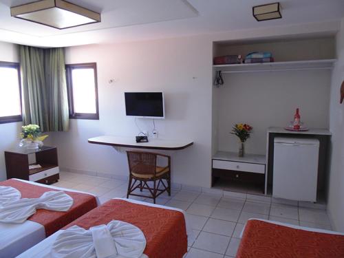Habitación de hotel con 2 camas y escritorio en Pousada Solar Ponta Negra, en Natal