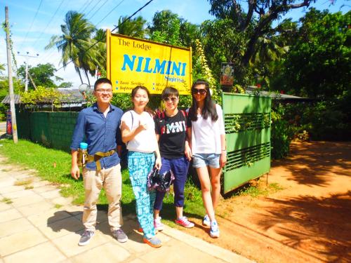 a group of people standing in front of a sign at The Nilmini Lodge in Sigiriya