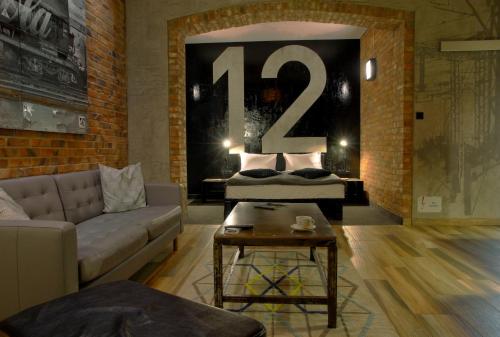 a living room with a couch and a bed with a large number at Browar CzenstochoviA Hotel&Spa in Częstochowa