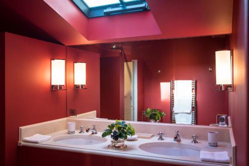 een badkamer met 2 wastafels en een grote spiegel bij Château Le Pape B&B in Léognan
