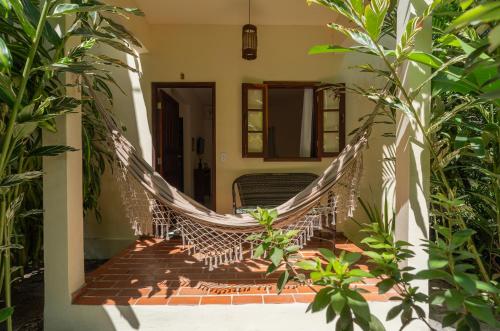 a hammock on the porch of a house at Pousada Samambaia in Trancoso