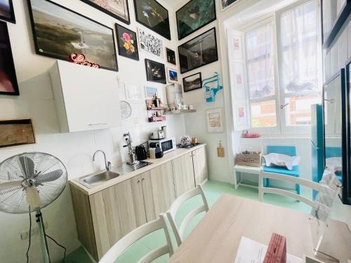 cocina con fregadero y mesa con ventilador en Hackert Art Room Apartment, en Caserta