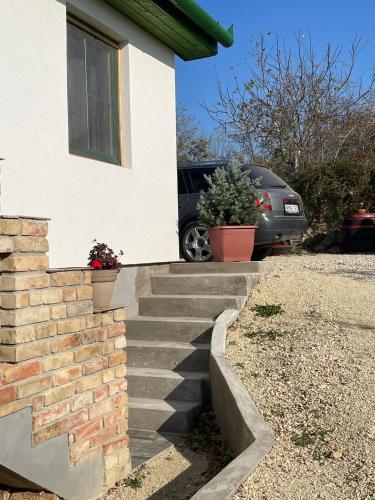 a house with stairs leading up to a driveway at Kőlépcsős Vendégház in Nyúl