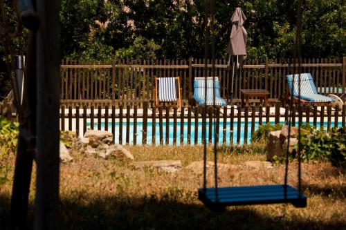 a fence with two chairs and a swimming pool at Mas Montluzia in Cascastel-des-Corbières