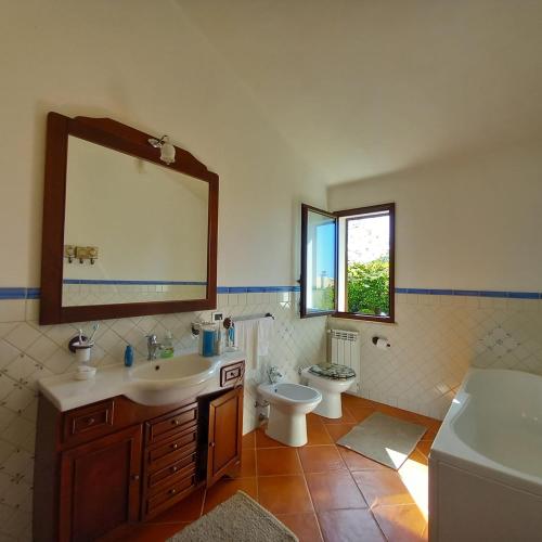 Un baño con lavabo, inodoro y espejo. en a due passi dal mare 1, en Marsala