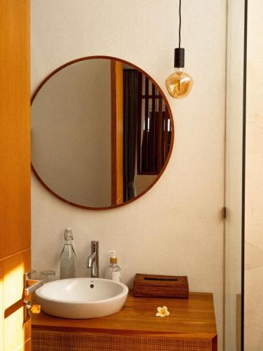 a bathroom with a sink and a large mirror at The Angsa villas in Amed