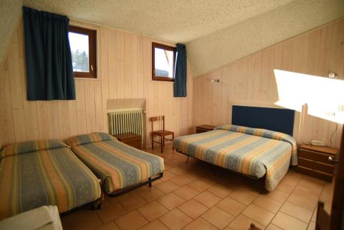 A bed or beds in a room at Albergo Bucaneve