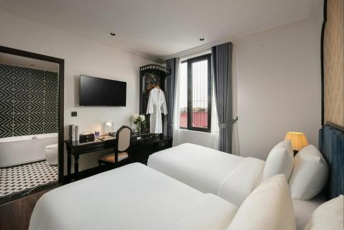 a white hotel room with a bed and a window at Phat Diem Plaza Hotel in Ninh Binh
