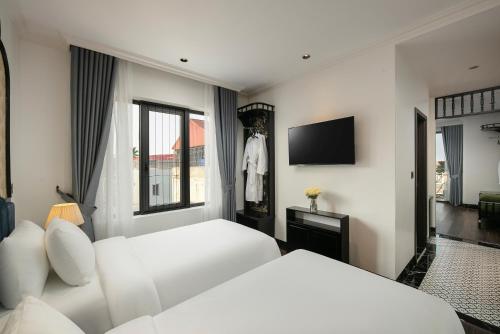 a hotel room with two beds and a television at Phat Diem Plaza Hotel in Ninh Binh