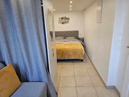 リュエイユ・マルメゾンにあるlogement entier indépendant dans maisonのベッドルーム1室(青いカーテンとソファ付きのベッド1台付)