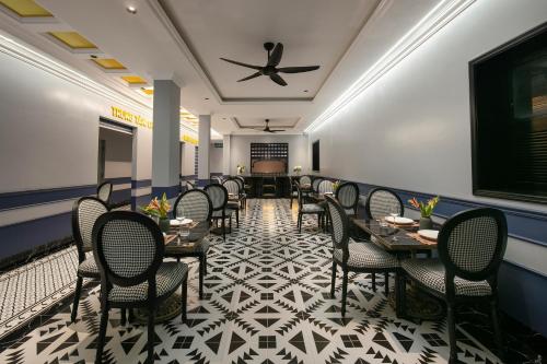 a dining room with tables and chairs and a ceiling at Phat Diem Plaza Hotel in Ninh Binh