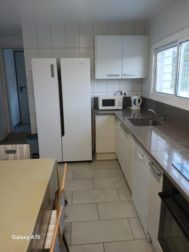 a kitchen with a white refrigerator and a sink at Appartement Almadrava Roses in Roses