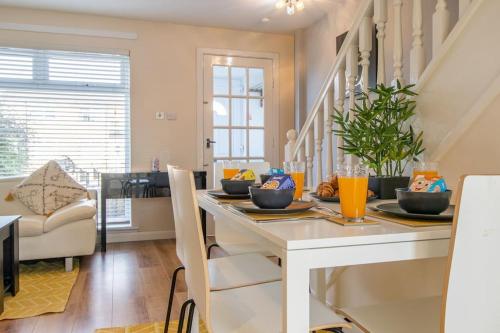 a dining room with a white table and chairs at Lena House in Glasgow