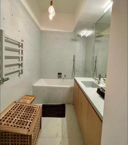 une salle de bain blanche avec une baignoire et un lavabo dans l'établissement Paris Appartement avec grande terrasse, à Paris