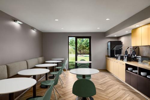 um restaurante com mesas e cadeiras verdes e uma cozinha em TownePlace Suites by Marriott Fort Meade National Business Park em Annapolis Junction