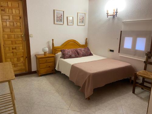 a bedroom with a bed and a dresser and a window at Hostal Cholo in Brañosera